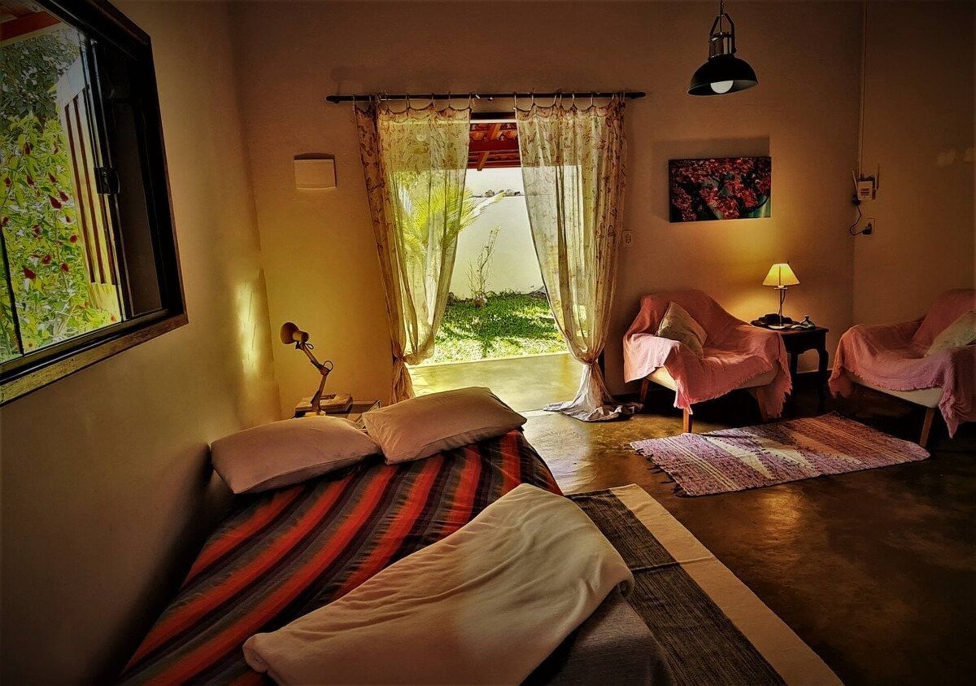 Quarto 2 da Casa da Artista, com cama de casal, cama de solteiro e tapete listrado