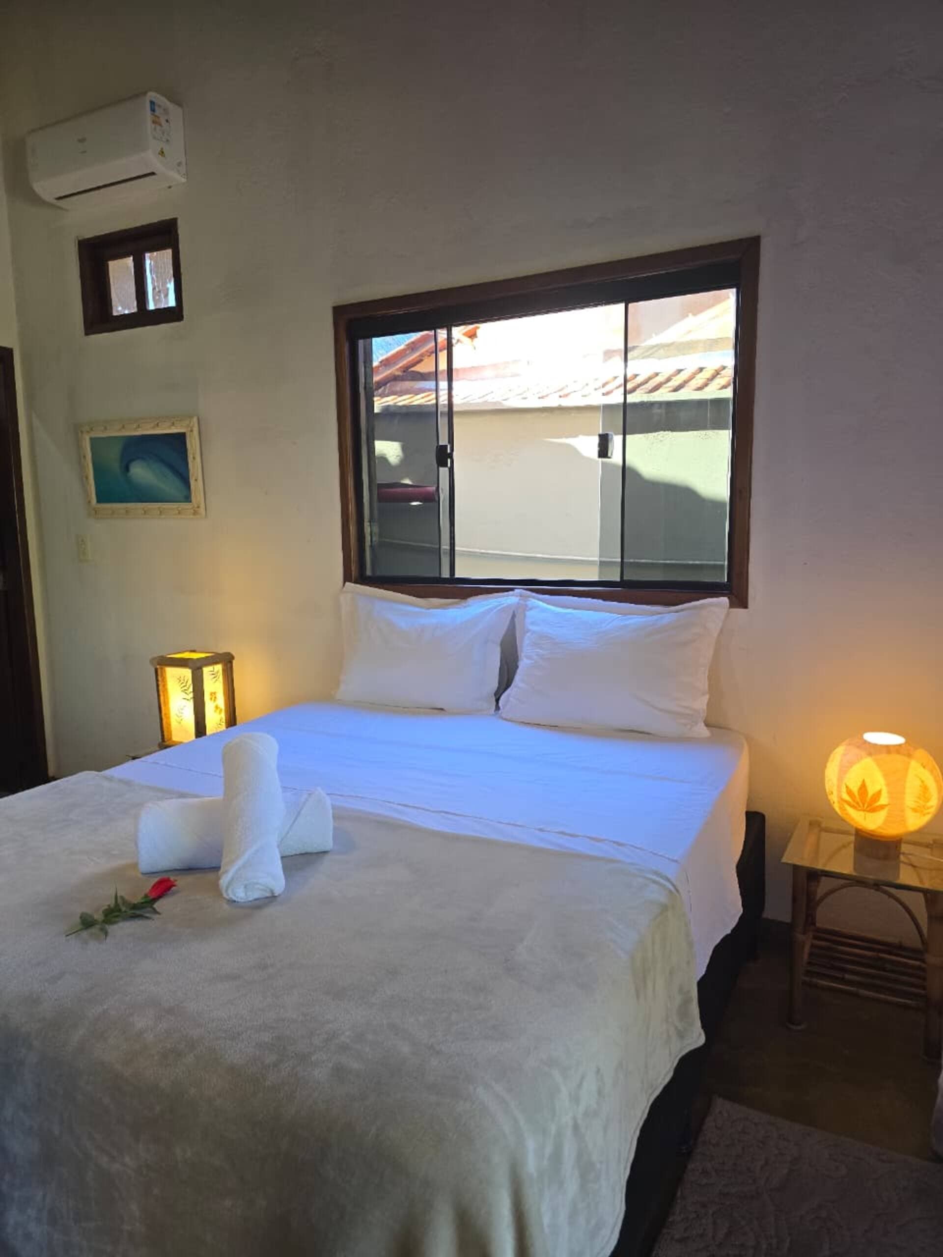 Suíte com cama de casal e luz da manhã