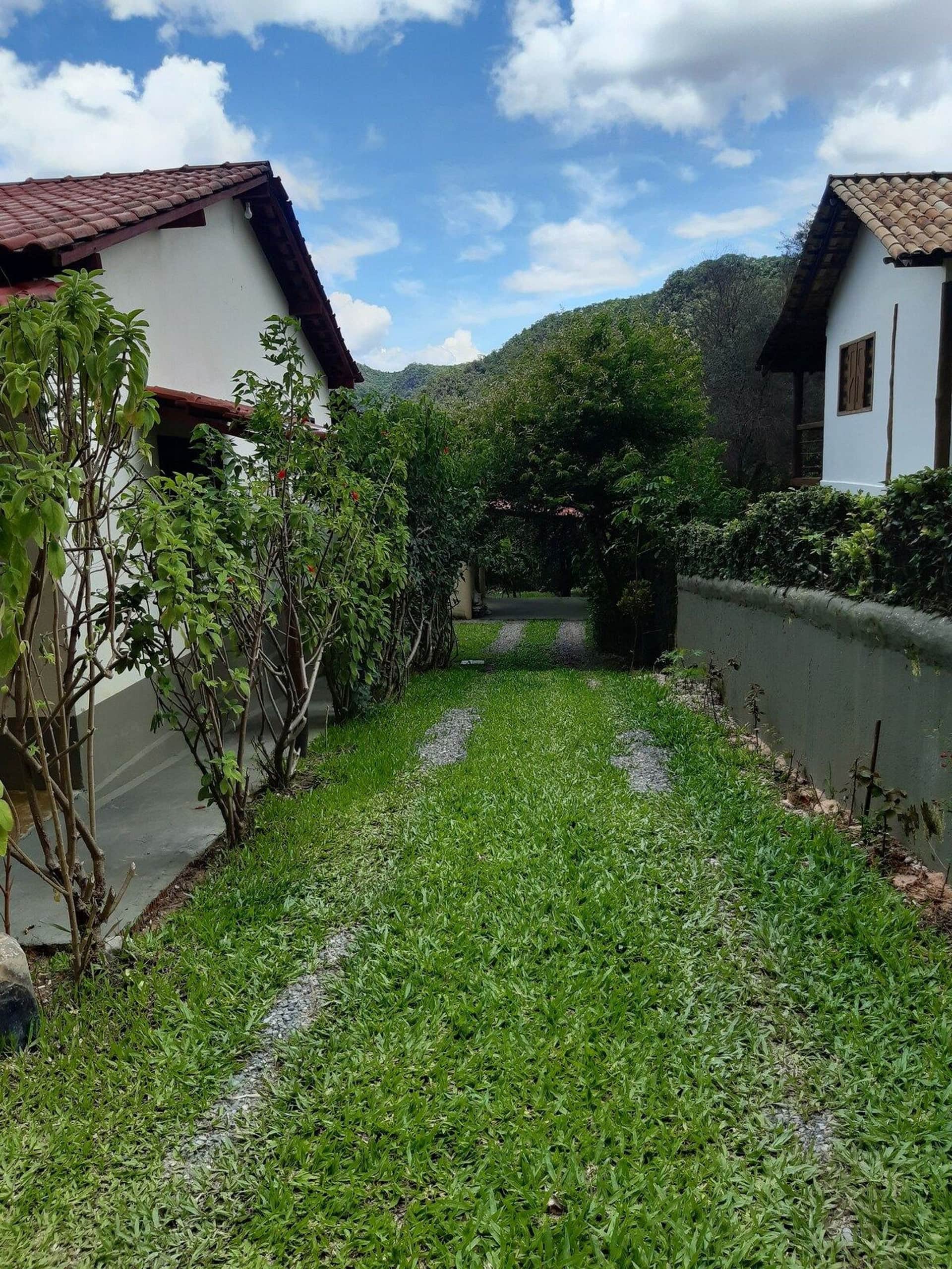 Caminho gramado da Casa da Artista, com as montanhas de Cavalcante ao fundo